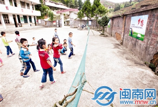 几名小学生在操场上玩，学校的围墙歪了一边，用简易