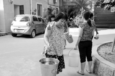 新华花苑小区居民挑水度日。实习生郑智鸿摄