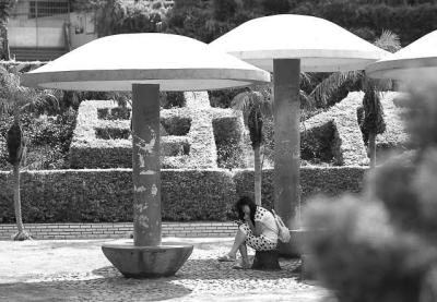 市民坐在李厝花园的亭子下，躲避灼热的阳光。