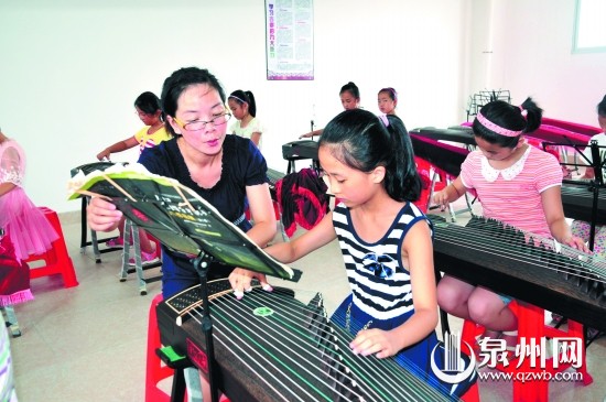 老师在指导学生弹奏古筝