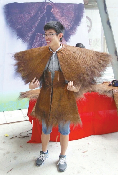 来宾兴致勃勃地试穿陈奕培制作的蓑衣。