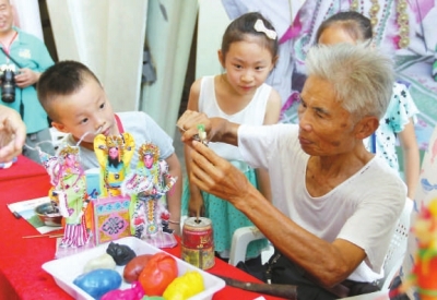 肖其昌在传授小朋友妆糕人制作技艺。