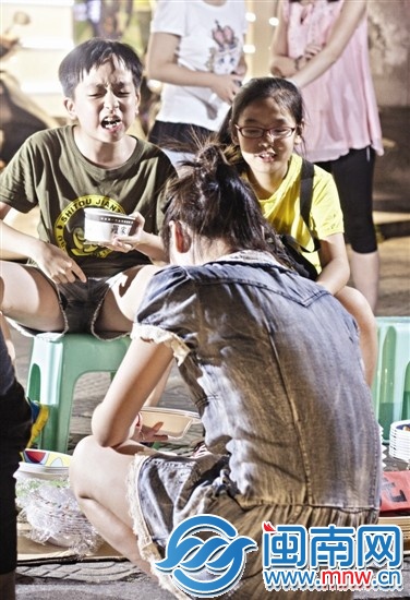 边吃臭豆腐边和客人推介的孩子，一脸认真