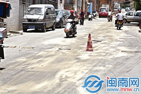 津宝路上的油污，两个好心人已经用沙子铺在路上