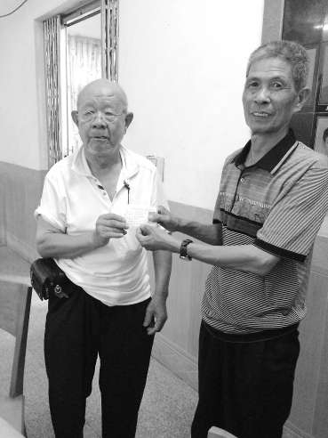 吴基扬（左）将办好的证件递交给村民。