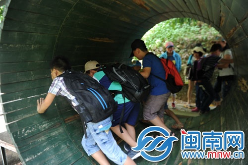 小记者合力喊“一二三推”,大木桶飞快向前滚动