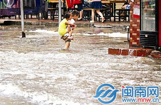 小哥哥背着小妹妹艰难涉水