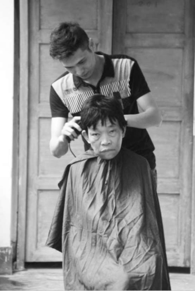 梁江华正在给老人理发。